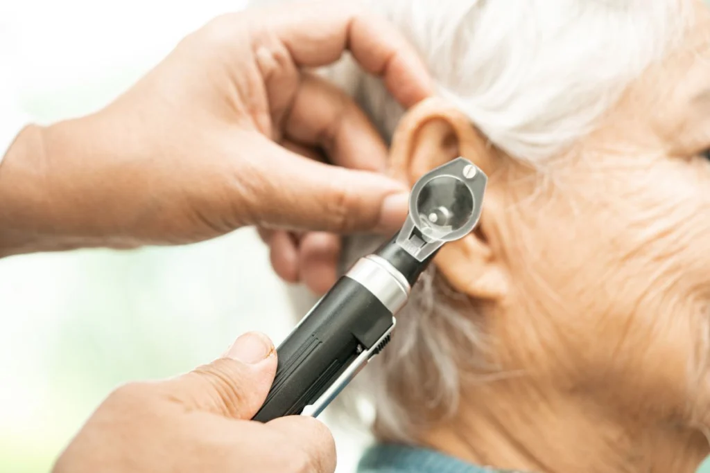 Audiologist examining patient’s ear during hearing evaluation at Rescue Hearing
